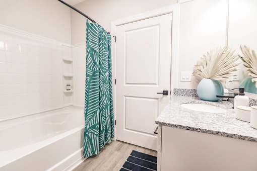 a bathroom with a shower and a sink at  a living room with tables and chairs and a ceiling fan at Swiftwater apartments in Port Charlotte, FL