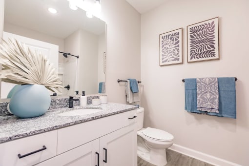 a bathroom with a sink and a toilet at  a living room with tables and chairs and a ceiling fan at Swiftwater apartments in Port Charlotte, FL