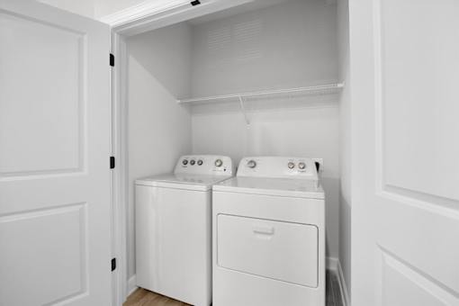 A white laundry room with a washer and dryer.
