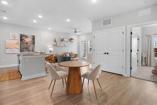 A kitchen with a dining table and chairs in the middle of the room.