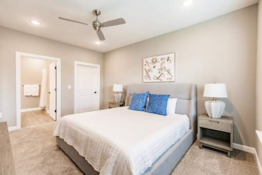 a bedroom with a bed, a night stand, and a bathroom