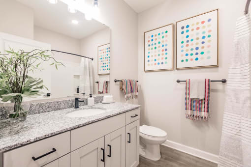 a bathroom with a sink and a toilet at  a living room with tables and chairs and a ceiling fan at Swiftwater apartments in Port Charlotte, FL