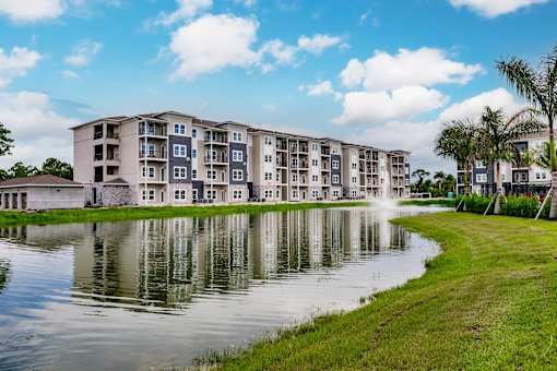Vantage apartment building overlooking a pond with a fountain