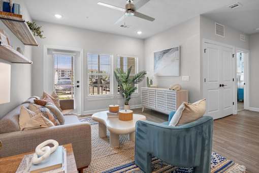 A living room with a grey couch, a blue chair, and a wooden coffee table.