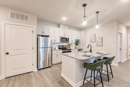 an open kitchen with an island and stainless steel refrigerator at swiftwater luxury apartments in port charlotte, fl