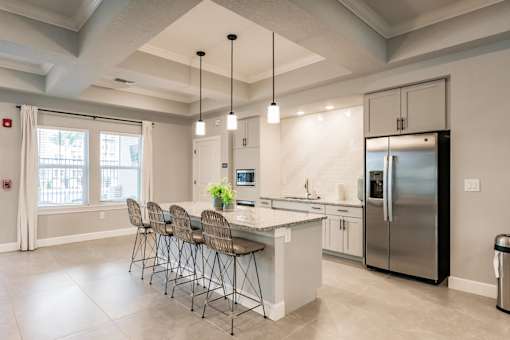 community kitchen with a chairs, a bar, and appliances at Vantage Luxury Apartments in  Cape Coral, FL