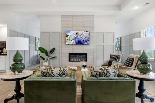 A living room with two green couches and a fireplace.