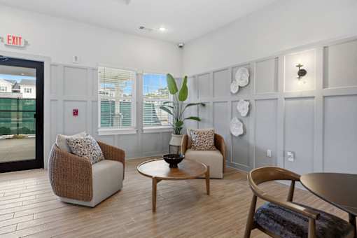 A living room with a chair, a sofa, a table, and a plant.