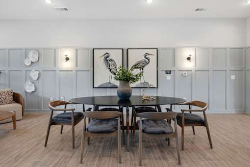 A dining room with a round table and chairs.