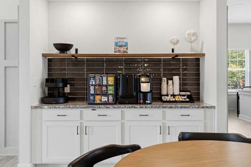 A kitchen with a wooden table and white cabinets.