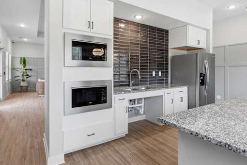 A modern kitchen with a refrigerator, oven, and sink.