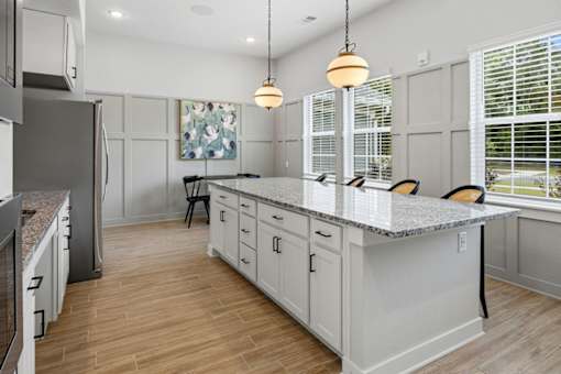 A kitchen with white cabinets and a granite countertop.