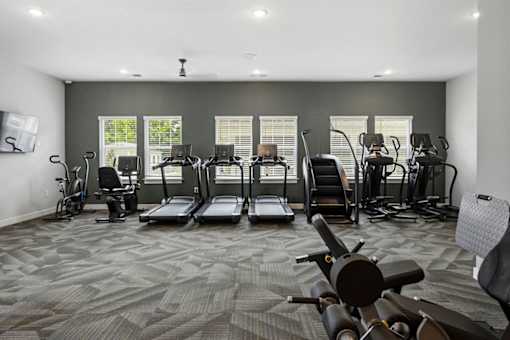 A gym with treadmills, elliptical machines, and other exercise equipment.