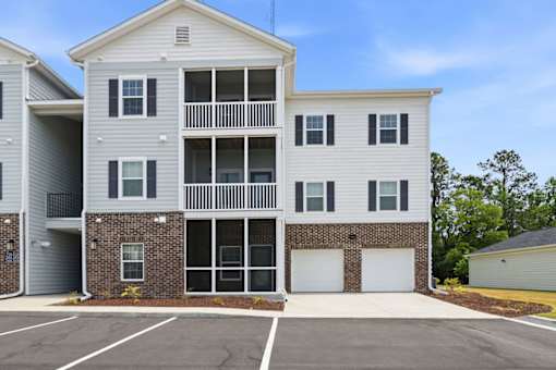 A two-story apartment building with a parking lot in front.