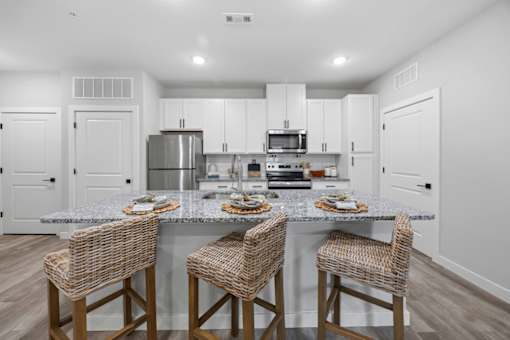A kitchen with a granite countertop and white cabinets.