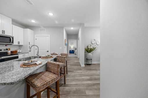 A kitchen with a counter and chairs.
