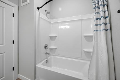 A white bathroom with a tub and shower.