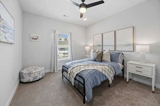 A bedroom with a bed, a dresser, and a ceiling fan.