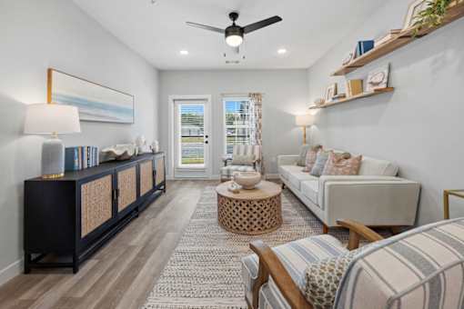 A living room with a striped couch and a ceiling fan.