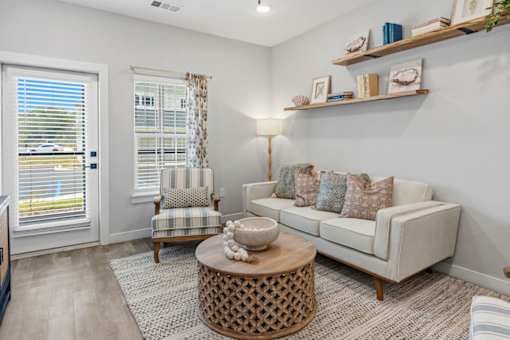 A living room with a sofa, armchair, and a coffee table.