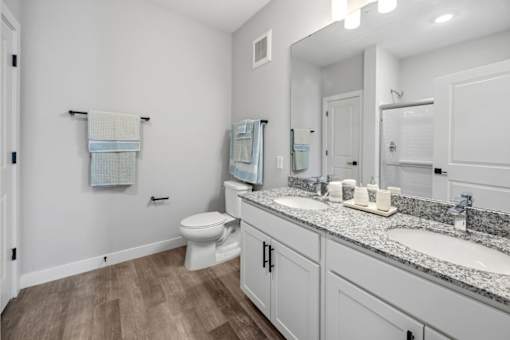 A bathroom with a toilet, sink, and mirror.