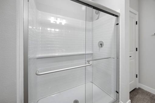 A white bathroom with a glass shower door.