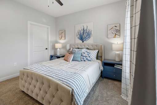 A bedroom with a large bed and two lamps.