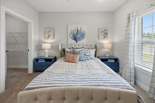 A bedroom with a large bed and two lamps.