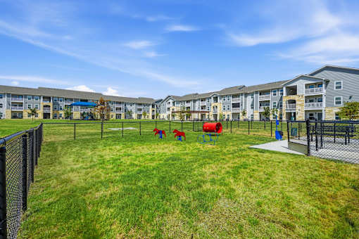 A playground area with a slide and swings in front of apartment buildings.
