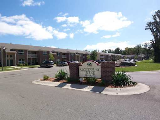 The Canterbury House apartments are surrounded by a well-maintained landscaped area.