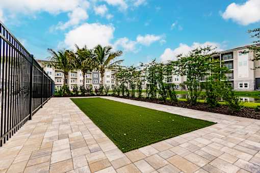 a courtyard with grass and trees in front of Vantage apartment buildings