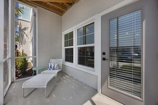 A patio with a white chair and table.