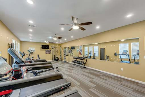 A spacious gym with treadmills, elliptical machines, and other exercise equipment.
