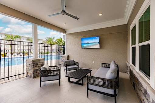 a patio with a couch and chairs next to a pool