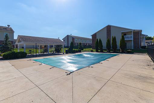 A swimming pool in a backyard surrounded by a fence.