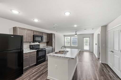 A kitchen with black appliances and wooden cabinets.