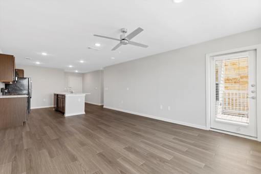A room with a ceiling fan and wooden flooring.