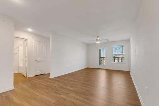 A room with wooden floors and a ceiling fan.