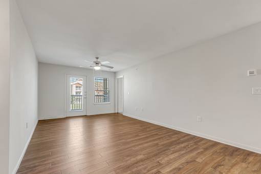 A room with wooden floors and a ceiling fan.