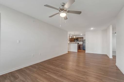 A room with a ceiling fan and wooden flooring.