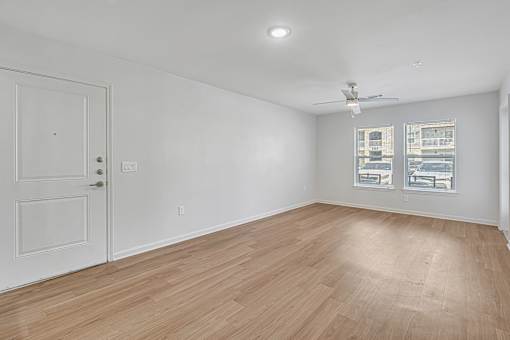 A room with a white door and a ceiling fan.