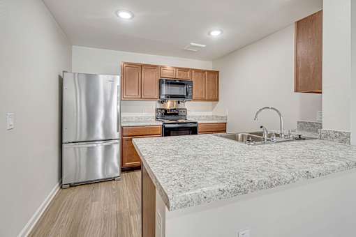 A kitchen with a granite countertop and stainless steel appliances.
