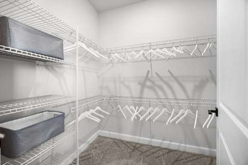 A white laundry room with a white ironing board and ironing rack.