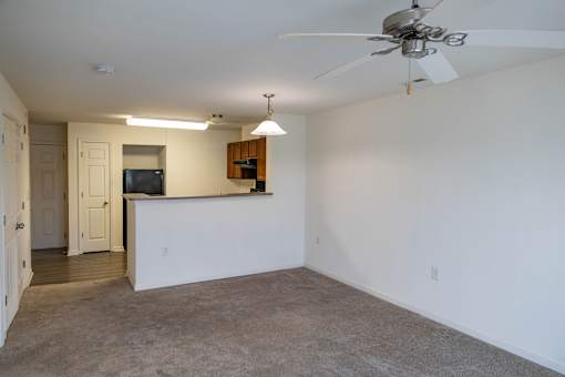 A spacious living room with a ceiling fan and a flat screen TV.