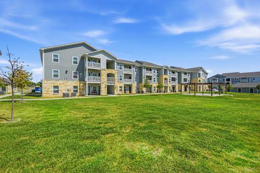 A large grassy area in front of apartment buildings.