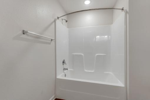 A white bathroom with a glass shower door.