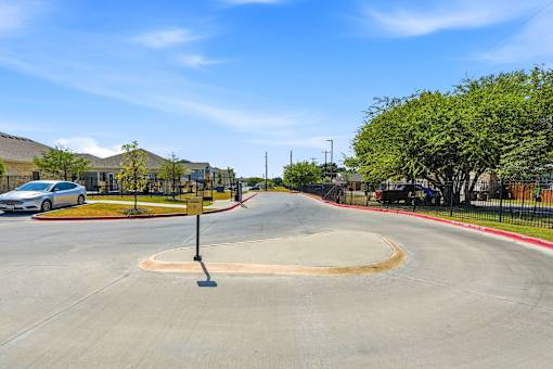 A roundabout with a sign on a pole in the middle of it.