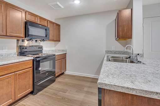 A kitchen with wooden cabinets and a black oven.
