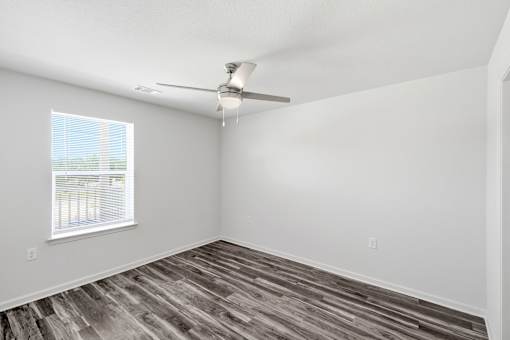 A room with a ceiling fan and a window.