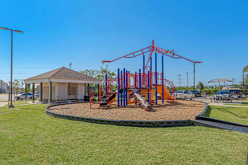 A playground with a red swing set and a yellow slide.